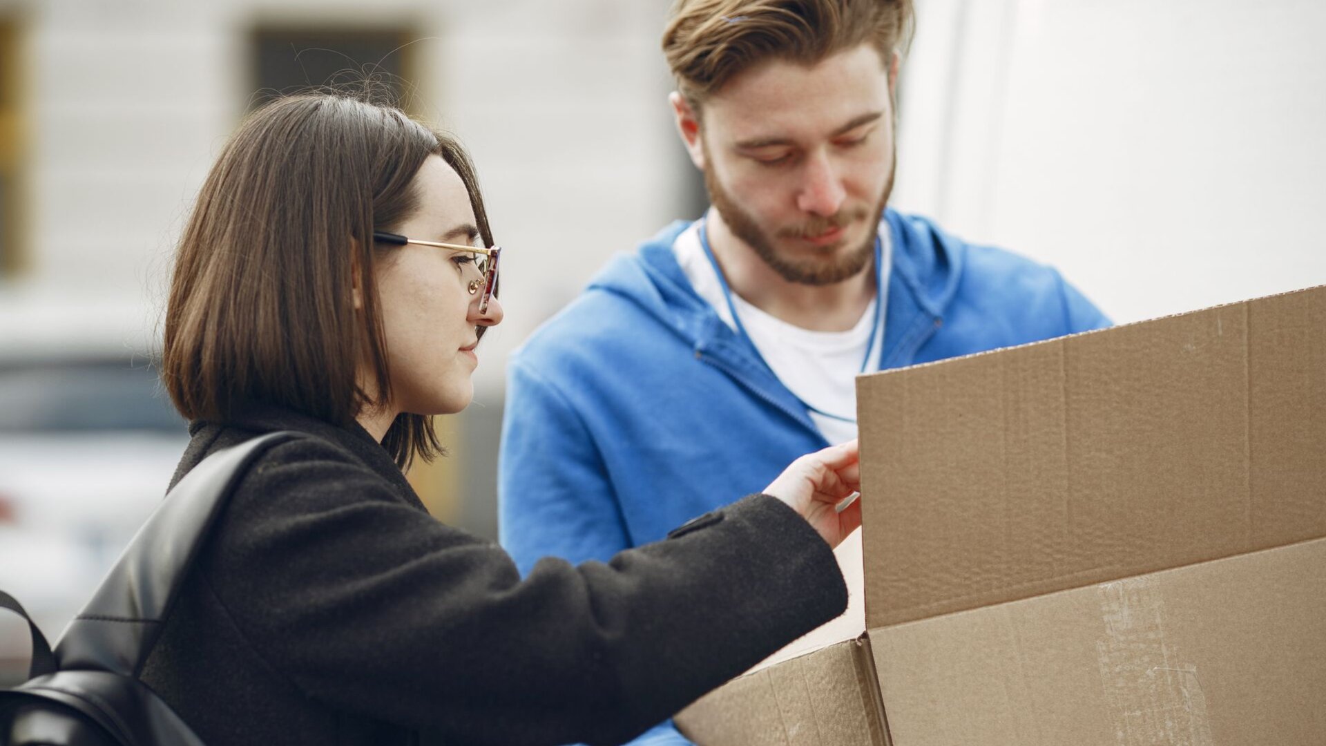 Mann und Frau öffnen gemeinsam ein Paket – Symbolbild für Online-Versandhandel und Umsatzsteuer beim Deemed-Reseller-Modell
