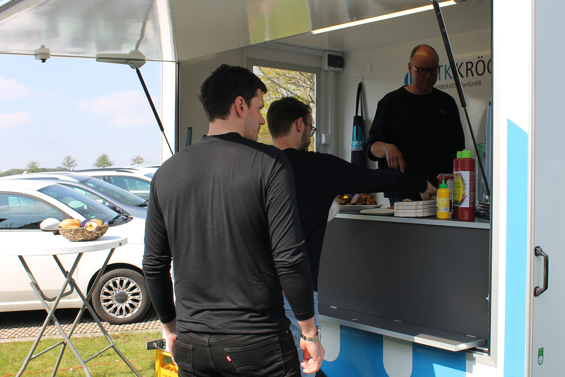 Beim Taxdoo-Besuch bei GTK Kröger Steuerberater steht der Chef, Kai Kröger, persönlich im GTK-Team-Grill. Davor: Dr. Moritz Lukas und Dr. Roger Gothmann