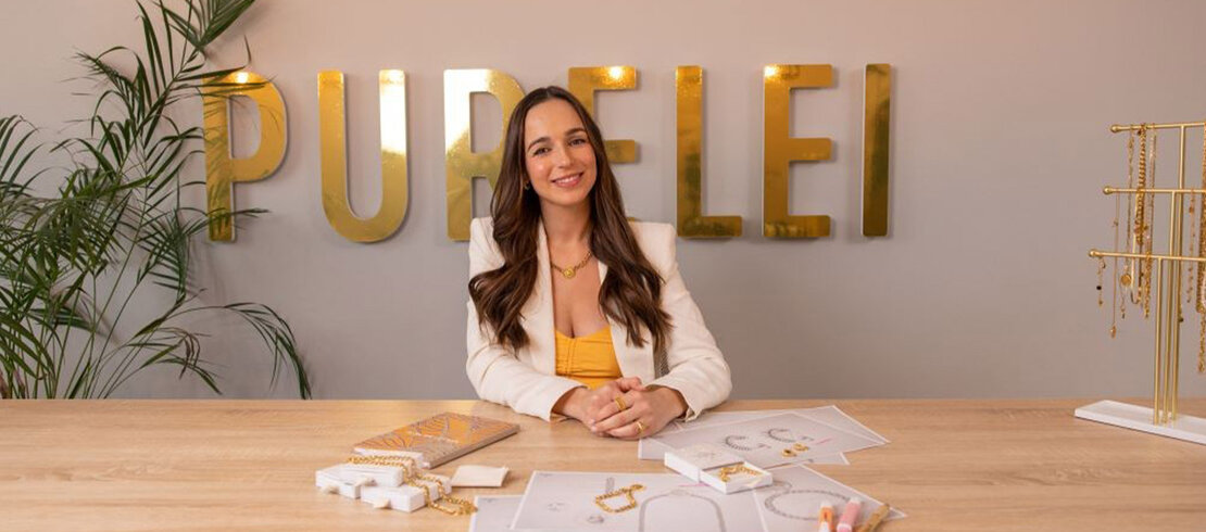 Alisa Jahnke im Office vor dem Logo von PURELEI