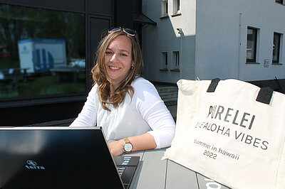 E Commerce Steureberaterin am mit großer Purelei-Tasche neben sich 